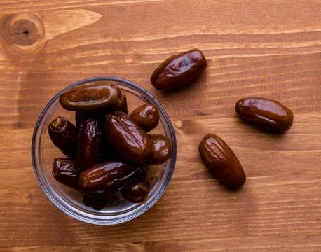 Dried dates on wooden table Stock Photos