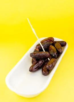 Dried dates on yellow background Stock Photos