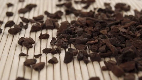 Dried decaffeinated chicory root granules fall on a bamboo mat Stock Footage 152142055
