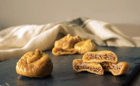 Dried figs with sliced one on dark rustic background Stock Photos