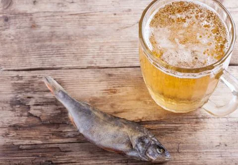 Dried fish with beer on the table background Stock Photos
