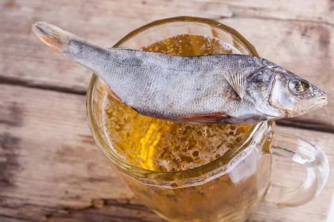 Dried fish with beer on the table background Stock Photos