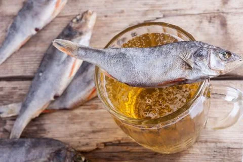 Dried fish with beer on the table background Stock Photos