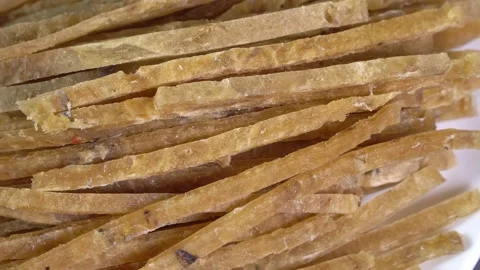 Dried fish fillet cut into strips rotates in a circle Stock Footage 169329033