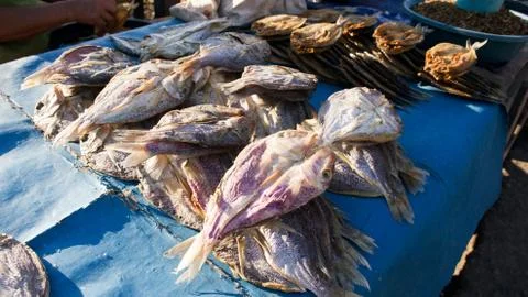 Dried fish in the sun on blue table sold at fish market. Stock Photos