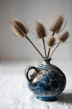 Dried flowers with thorns in a handmade ceramic blue vase Stock Photos