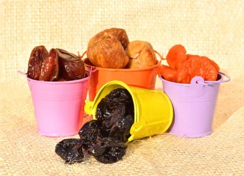 Dried fruit, dates, figs, prunes, apricots on the colored pots Stock Photos