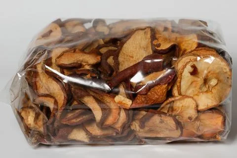 Dried fruit in a plastic bag close-up on a gray background. Stock Photos