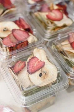 Dried fruit snacks in clear plastic containers, assorted flavors visible Stock Photos