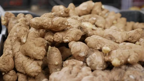 Dried ginger roots are displayed in close view on a market table, showing rough Stock Footage 329922581