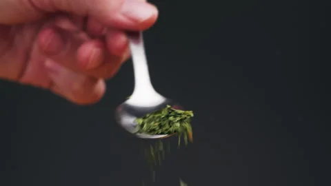Dried green dill on spoon close-up macro. Spice for food. Man hand strewing dill Stock Footage 263087713