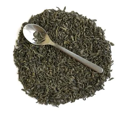 Dried green leaf tea and a spoon Stock Photos