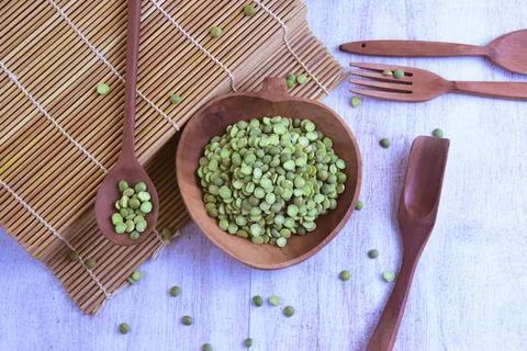 Dried green split peas inside wooden bowl on the side of sushi roller with .. Foto stock