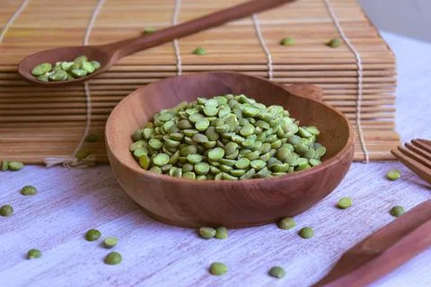 Dried green split peas inside wooden bowl on the side of sushi roller with .. Stock Photos