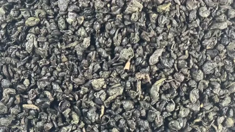 Dried green tea rotates clockwise close up Stock Footage 131415269
