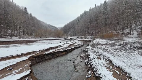 A dried lakebed with a meandering stream stands out in the snowy landscape... Stock-Footage 295954030