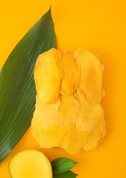 Dried large sweet mango slices on yellow background.Top view. Stock Photos