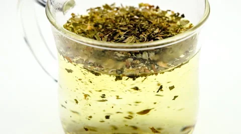 Dried loose leaf peppermint tea dissolving in water Stock Footage 45028027