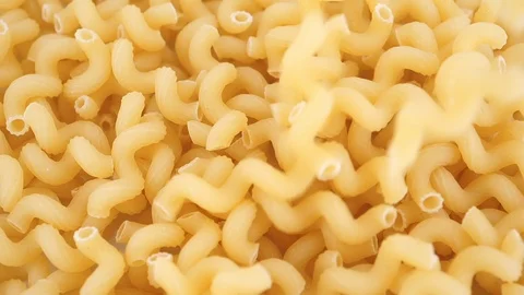 Dried macaroni pasta falling on a heap, top view, slow motion Stock Footage 92670675