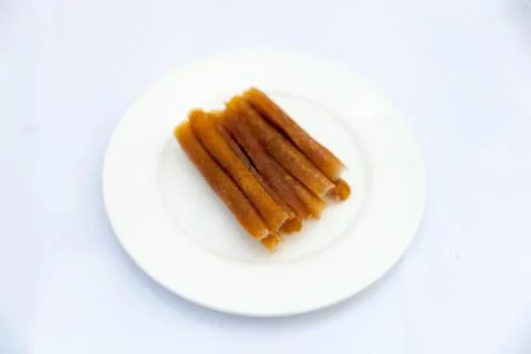 Dried mango paste on white plate on white Foto stock