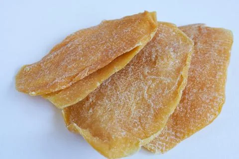 Dried mango slices, close-up on white. Stock Photos