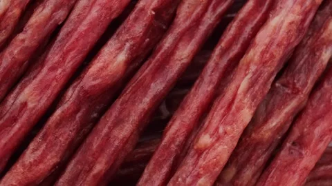 Dried meat in the form of thin sausages, rotation in circle. meat beer snack Stock Footage 241251180