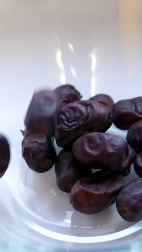 Dried medjool dates falling into a wooden rattan bowl closeup. Arabic dessert Video stock 305979811