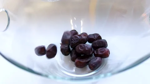Dried medjool dates falling into a wooden rattan bowl closeup. Arabic dessert Video stock 305988865