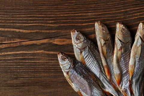 Dried or jerky salted roach, clipfish on wooden background. Salty beer appetizer Stock Photos