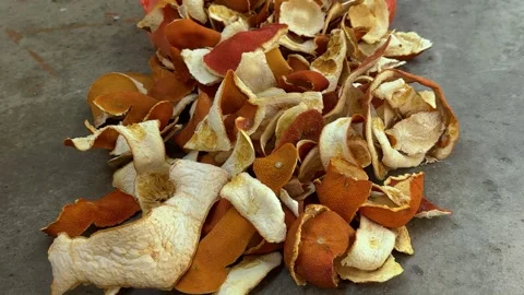 Dried orange peels piled on grey concrete floor, citrus rind waste  Video stock 343405853