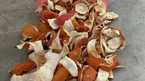 Dried orange peels scattered on a gray concrete floor. Citrus zest Video stock 341830119