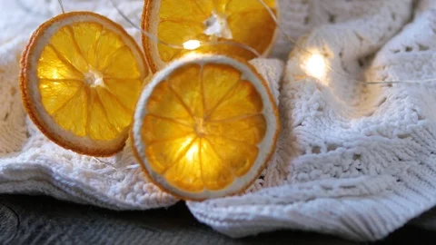 Dried orange slices, christmas decor. white plaid with a garland. close-up Vidéo 99463129