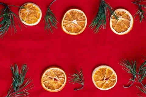 Dried oranges and pine branches on a red background Stock Photos