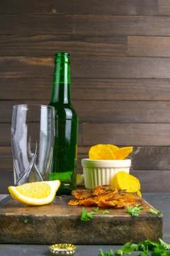 Dried perch with beer, lemon and potato chips on dark wooden board. Snack on  Stock Photos