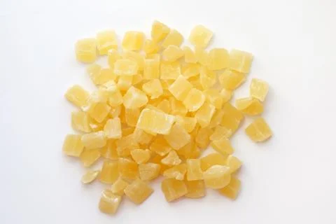 Dried pineapple cubes on a white background. Stock Photos