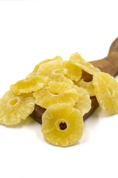 Dried pineapple slice isolated on white background. Dried fruit in sunlight.  Stock Photos