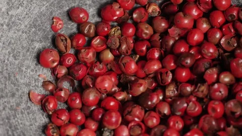 Dried pink pepper falling down in grey plate close-up. A bunch of natural pink Stock Footage 263085934