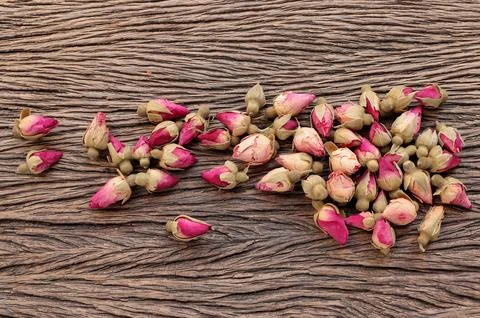 Dried pink rose buds on the table. Tea rose flowers background.  Stock Photos