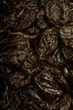Dried prunes in bulk. Surface texture. Close up. Stock Photos