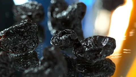 Dried Prunes, Close up of dried plums falling to water table 4K. Slow Motion. Stock Footage 114964074