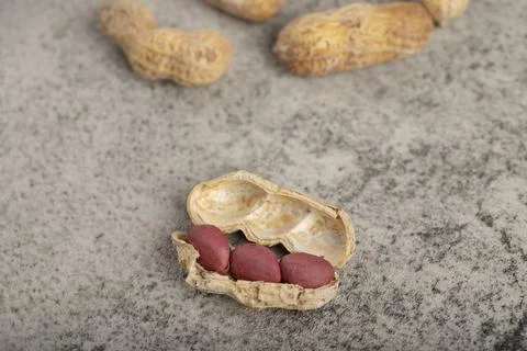 Dried raw organic peanuts placed on stone surface Stock Photos