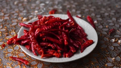 Dried red chilli falling on a white plate Stock Footage 332688715