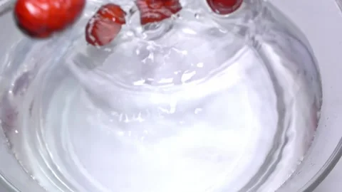 Dried red dates dropped into water with splashes, top view, slow motion Video stock 156699700