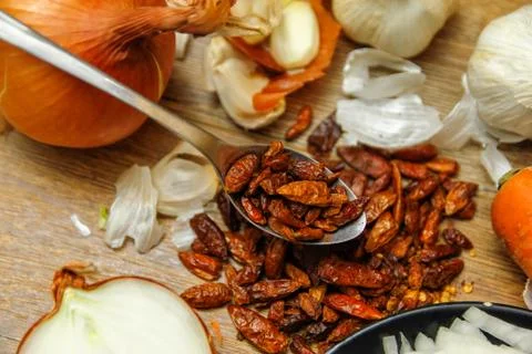 Dried red hot small chilli peppers in spoon Stock Photos