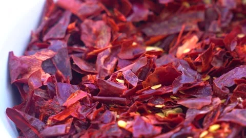 Dried red pepper flakes creating a vibrant cooking ingredient background Vidéo 333497327