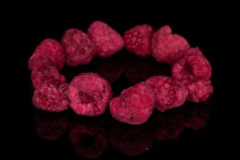 Dried red raspberry isolated on black glass Foto stock