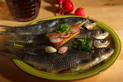 Dried roach, traditional beer appetizer toast with fish fillet on a green plate Stock Photos