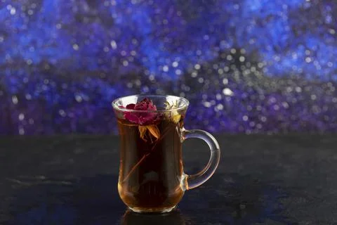 Dried rose in a cup of hot tea on a black background Stock Photos