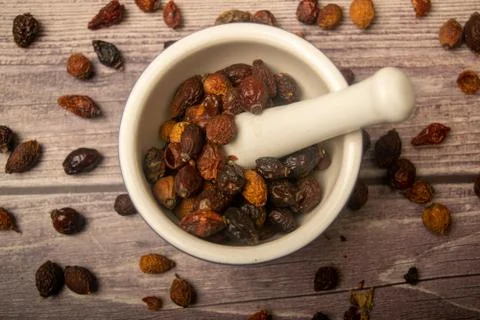 Dried rosehip fruit in a ceramic mortar and dried rosehip fruit in bulk on a  Stock Photos