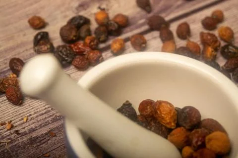Dried rosehip fruit in a ceramic mortar and dried rosehip fruit in bulk on a  Stock Photos